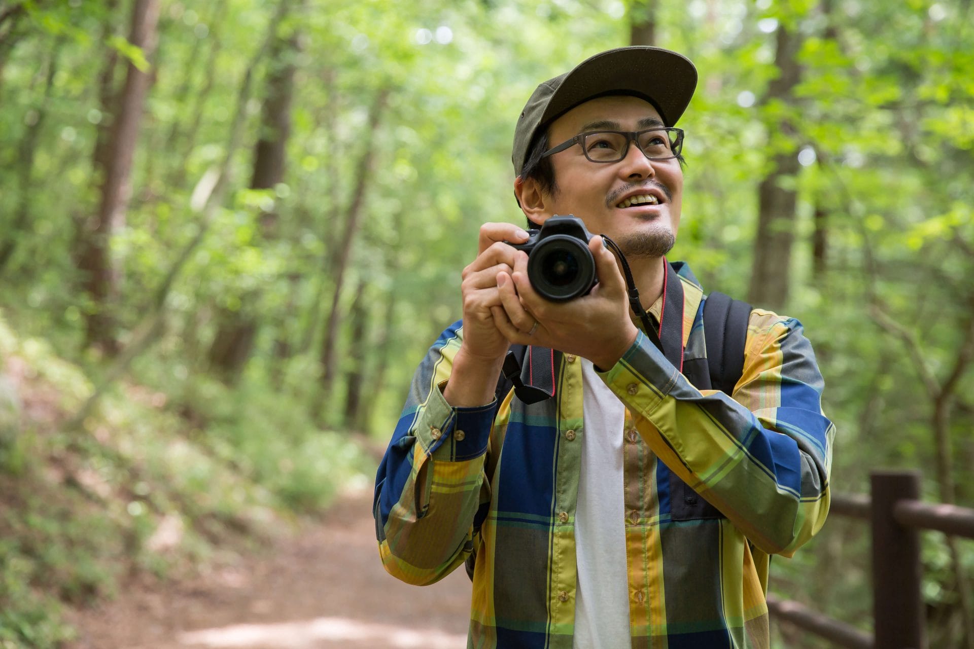 person walking in woods with camera