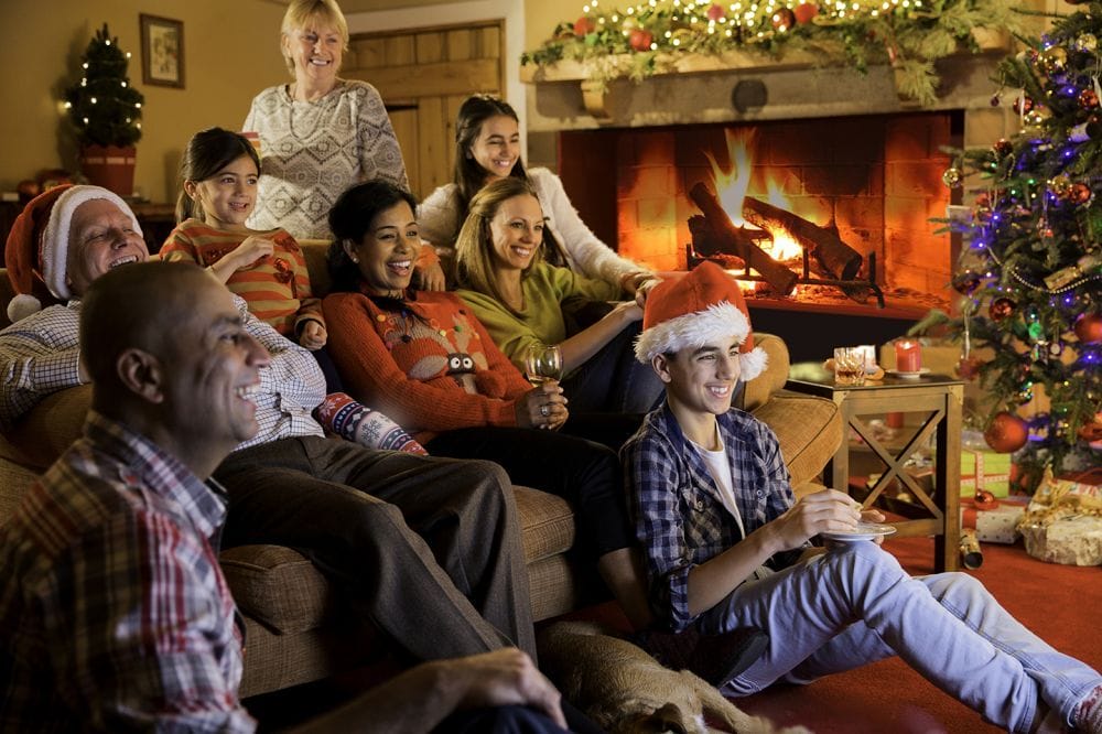 Happy family gathered by the fireplace during the holidays, emphasizing the importance of respiratory health and indoor air quality in winter