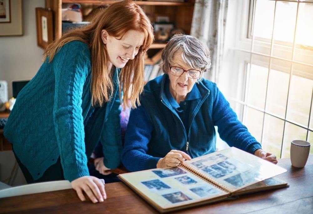 older woman and younger woman looking through family photo album