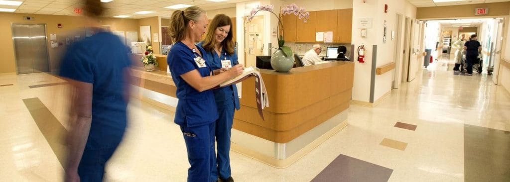 Two nurses talking at nurses' station