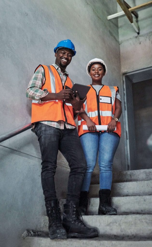 two people wearing safety vests and helmets