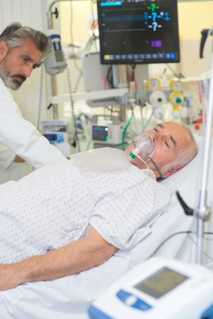 man with oxygen in hospital bed