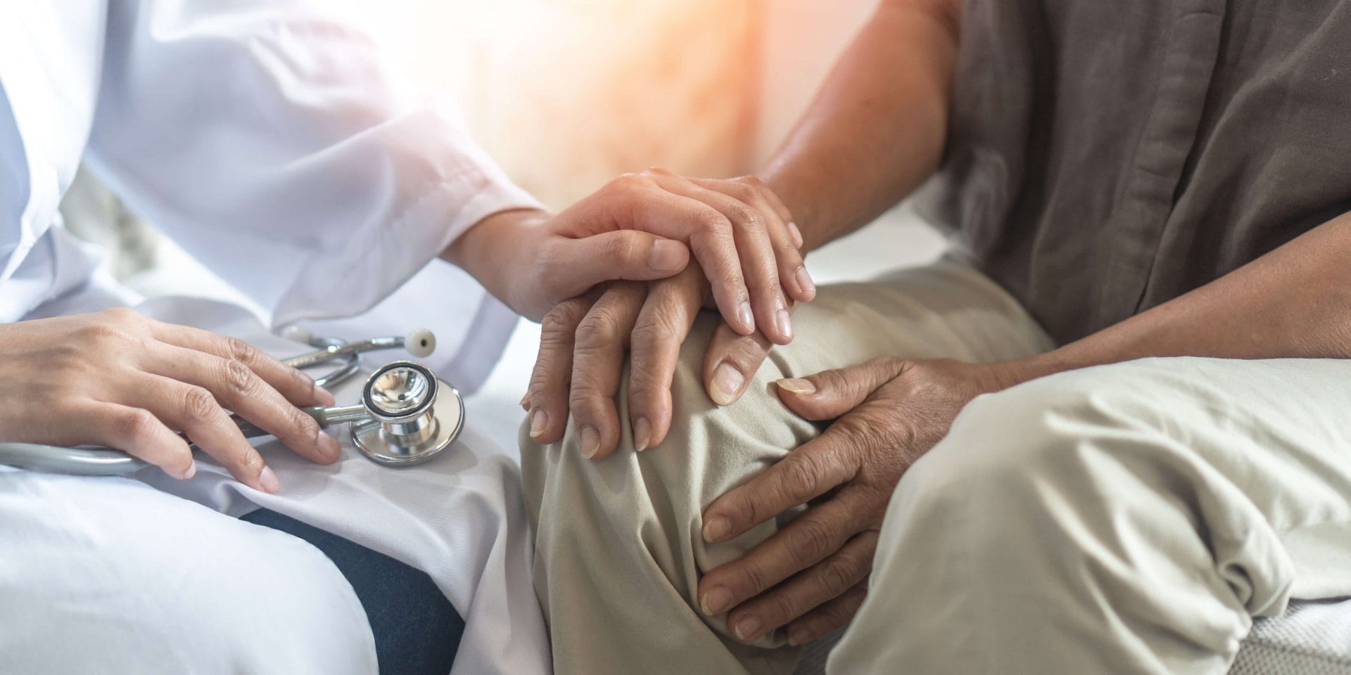 caregiver holding a patient's hands