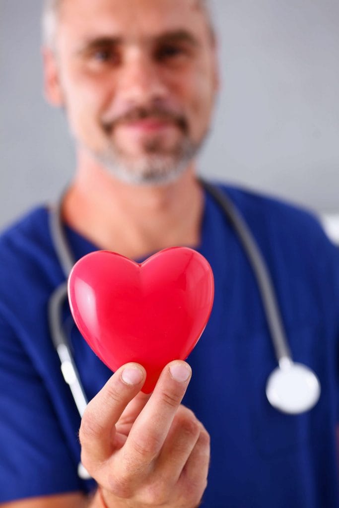 man holding a plastic heart