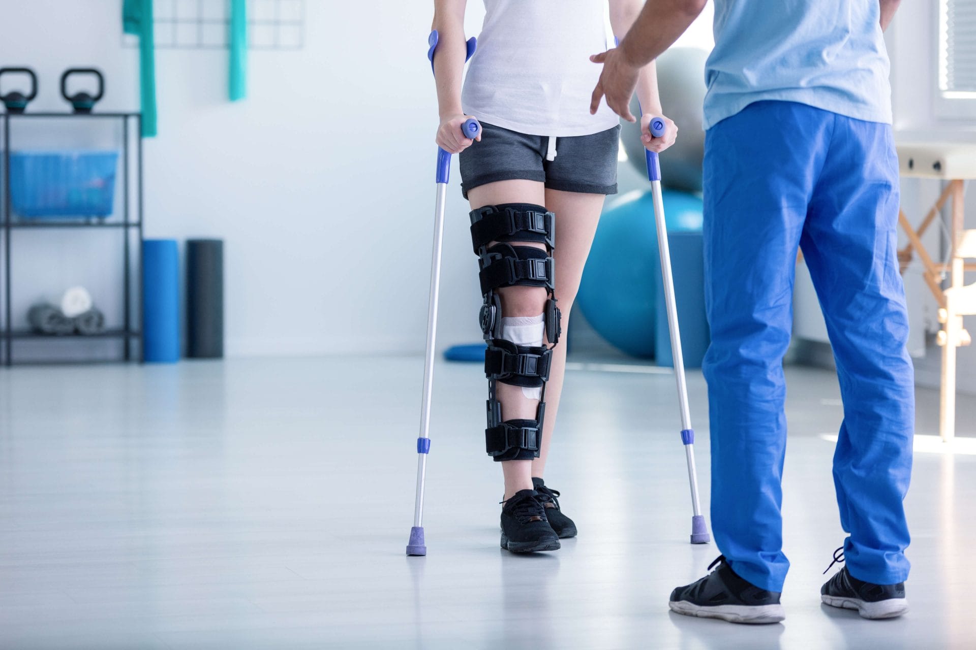 woman walking with crutches and leg brace